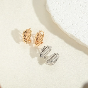 Exquisite 14K gold and silver leaf-shaped earrings on a minimalist white stone background