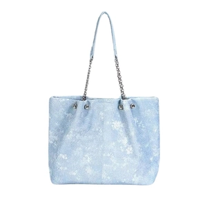 Light blue denim tote bag with silver chain straps and white snowflake texture pattern
