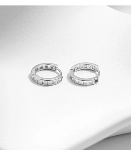 Detailed macro view of S925 silver U-shaped hoop earrings with shimmering clear zircons
