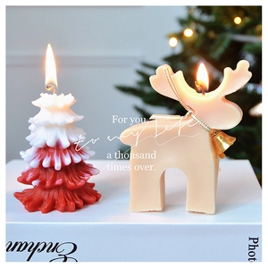 Detail view of handmade Christmas tree and reindeer scented candles with a festive backdrop