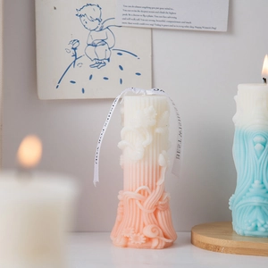 Detail of relief art candles with gradient finish and decorative ribbons in cozy setting