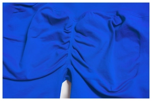 Detail shot of bright blue scrunch butt yoga shorts showing elastic knit texture