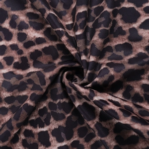 Close-up of leopard print fabric with soft pleats and fluid drape for summer dress