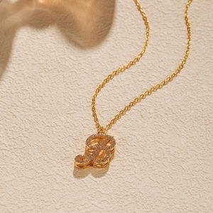 Macro detail of 18K gold plated O-chain necklace featuring a zircon-encrusted letter pendant