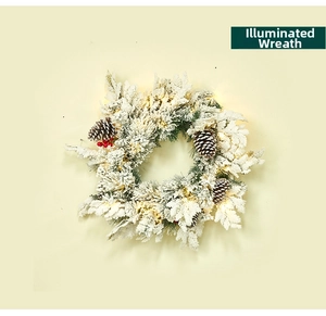 Close-up of snowy Christmas wreath with red berries, pine cones and warm LED lights