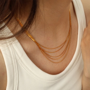 Minimalist multi-layered gold snake chain necklace in stainless steel shown on model