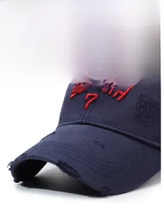 Detailed close-up of vintage navy baseball cap with red 3D embroidery and distressed edges