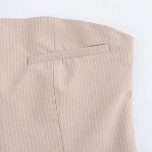 Close-up of beige pinstriped fabric featuring a professional welt pocket and fine texture