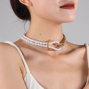 Detail view of double-layer necklace with white faux pearls and golden metal beads