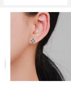 Close-up of star-shaped stud earrings with turquoise stones and rose gold finish