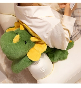 Close-up of soft green triceratops plush cushion used as a comfy backrest on a sofa