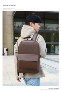 Side view of dark brown faux leather business backpack worn by model in urban street setting