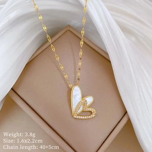 Close-up of double heart pendant with white shell and diamonds on a gold necklace