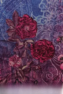 Macro shot of ethnic floral print fabric featuring vintage red roses and paisley details
