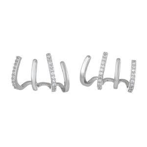 Macro view of silver claw earrings with sparkling zircon stones on white background