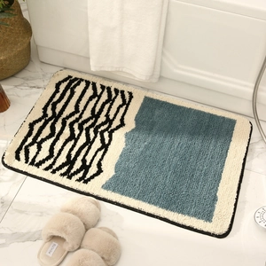 Plush non-slip bath mat with wave pattern and blue accents on bathroom floor