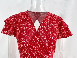 Detail of red polka dot dress with V-neckline and ruffled short sleeves for summer