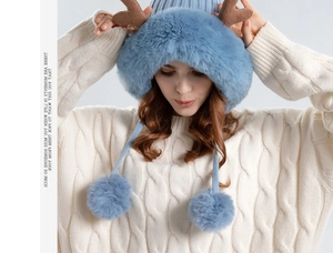 Detail of light blue winter knit hat featuring plush reindeer antlers and double pom poms