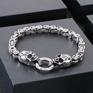 Macro detail of punk skull charm and chunky Byzantine chain on black gift box