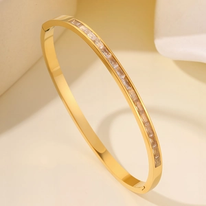 Detail of gold titanium bracelet featuring a single row of rectangular crystals