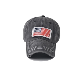 Close-up of faded black washed cotton baseball cap with American flag embroidery and distressed detail
