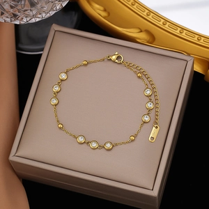 Polished 18K gold plated stainless steel bracelet with round zircon stones on jewelry box