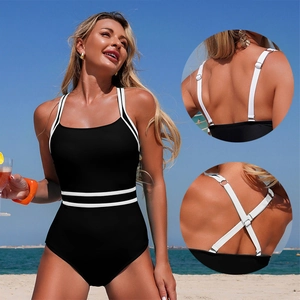 Classic black and white one-piece swimsuit with adjustable straps on beach background