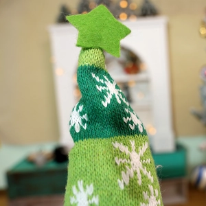 Green knitted Christmas gnome hat with snowflake patterns and a felt star ornament