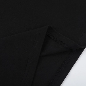 Vue macro détaillée de l'ourlet de la robe en maille noire montrant les coutures