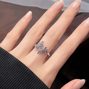 Close-up of sparkling blue butterfly ring with zircon stones on female finger