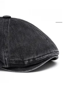 Detail of grey washed denim newsboy cap showing reinforced brim and textured fabric