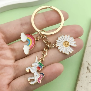 Cute golden keychain featuring colorful rainbow unicorn and daisy enamel pendants
