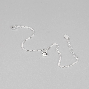 Close-up of S925 sterling silver lock bracelet with engraved smiley face and lobster clasp