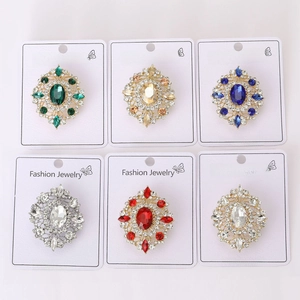 Close-up of vintage oval crystal brooches in assorted colors with rhinestone accents
