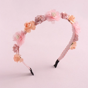 Detailed view of handmade pink and orange fabric floral headband with non-slip base