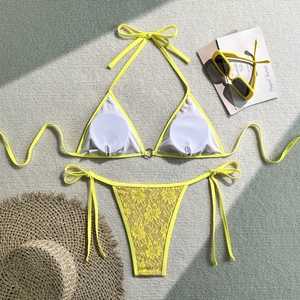 Detailed close-up of yellow lace bikini featuring a golden ring and floral crochet pattern