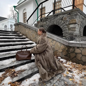 Long brown faux fur coat with thick plush texture and luxury oversized leather tote bag