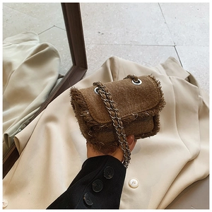 Detail of vintage tan textured mini bag with raw fringe edges and silver chain strap