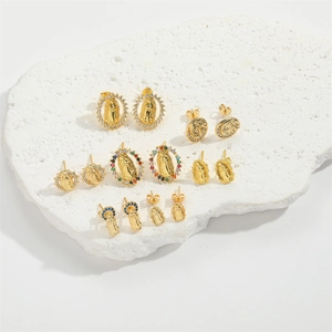 Set of 7 pairs gold religious stud earrings with colorful zircon on white stone stand