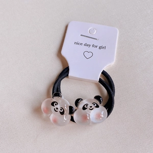 Nahaufnahme von süßen Panda-Haargummis mit rosa Wangen auf weißer Verpackungskarte