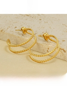 Detailed view of 18K gold plated titanium steel double hoop earrings on stone background