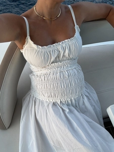 Dettaglio dell'abito lungo in cotone bianco con punto smock e scollo a balze