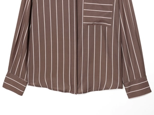 Detail of a brown striped long sleeve shirt showing horizontal striped pocket and sleeve cuff