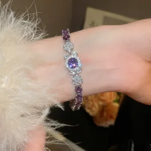 Elegantes Zirkon-Blumenarmband mit einem lila Mittelstein am Handgelenk eines Models gezeigt