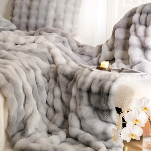 Close-up of premium silver grey faux fur blanket featuring thick plush texture on a sofa