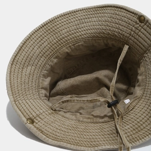 Close-up of khaki washed canvas hat with adjustable chin strap and bronze metal snap buttons