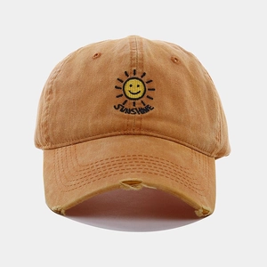 Close-up of vintage washed khaki baseball cap with sunshine embroidery and distressed brim