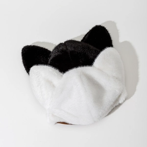 Detailed view of plush cat ear hat featuring black and white faux fur texture
