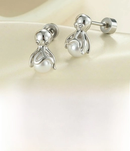 Detailed view of silver octopus-shaped cartilage stud earrings with round white pearls