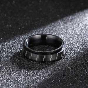6mm black 316L titanium steel spinner ring with carbon fiber texture on black background